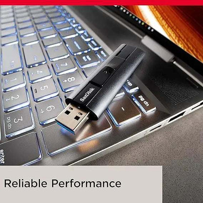 SanDisk Extreme PRO USB 3.2 flash drive plugged into laptop keyboard.